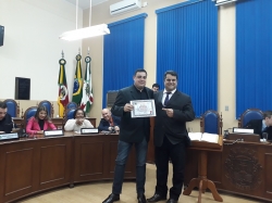 Roberto Zacouteguy recebendo diploma de 'amigo solidrio' pela Defesa Civil e Servios Urbanos